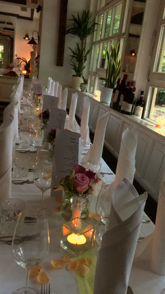 Festtafel im Innenraum mit Kerzen und weißen Tischdecken