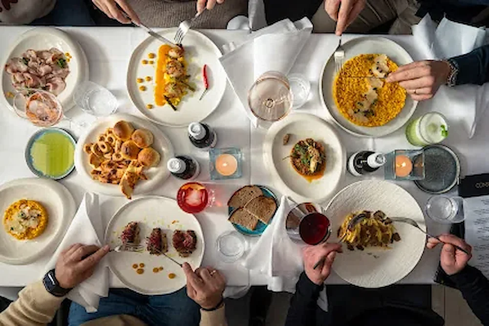 Geteilte Tafel von oben mit Risotto, Calamari und Antipasti — Ristorante Risotto München